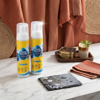 Two bottles of multipurpose foam cleaner on a kitchen counter with terracotta and burnt sienna accents.